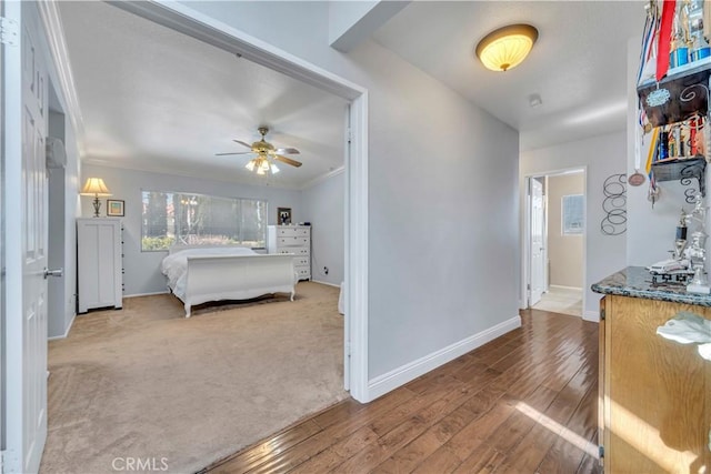 carpeted bedroom featuring wood finished floors and baseboards