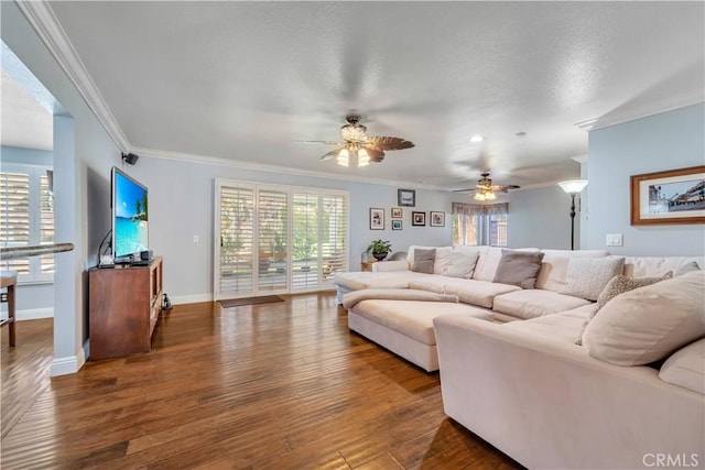 living room featuring a ceiling fan, wood finished floors, baseboards, a textured ceiling, and crown molding