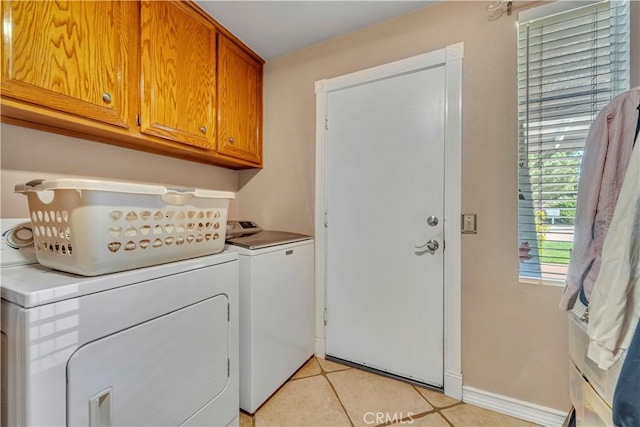 washroom with washing machine and clothes dryer, cabinet space, and baseboards