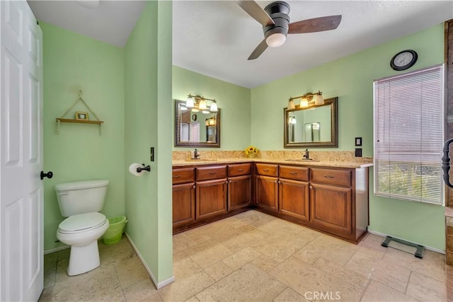 bathroom featuring toilet, baseboards, and a sink