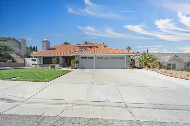 view of front facade with an attached garage, stucco siding, concrete driveway, a front lawn, and a tiled roof