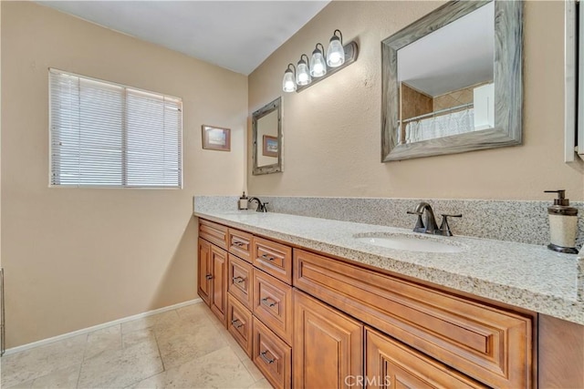 full bath with double vanity, a shower with curtain, baseboards, and a sink