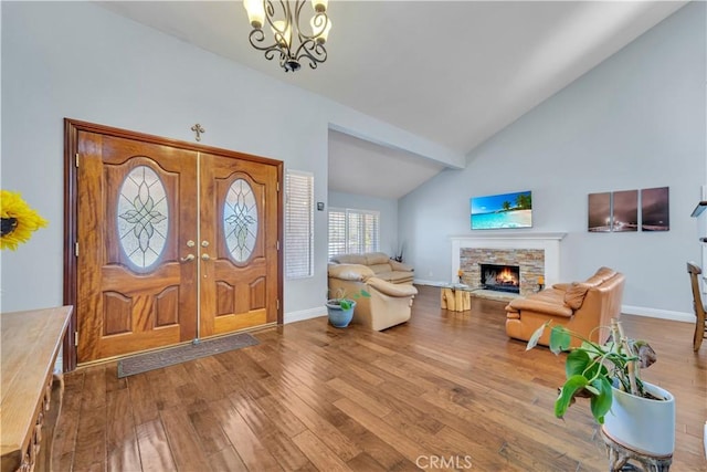 foyer featuring a fireplace, wood finished floors, and baseboards