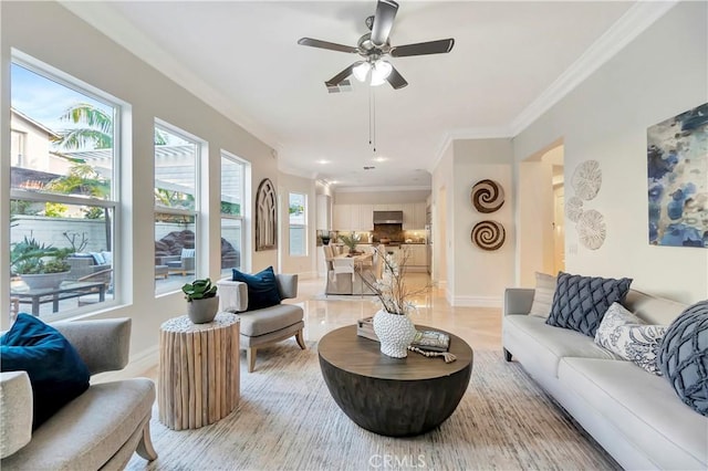 living room featuring visible vents, ceiling fan, baseboards, and ornamental molding