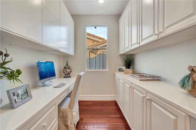 home office with dark wood finished floors, baseboards, and built in study area