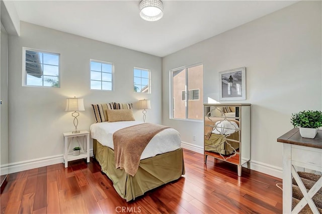 bedroom featuring dark wood-style floors and baseboards