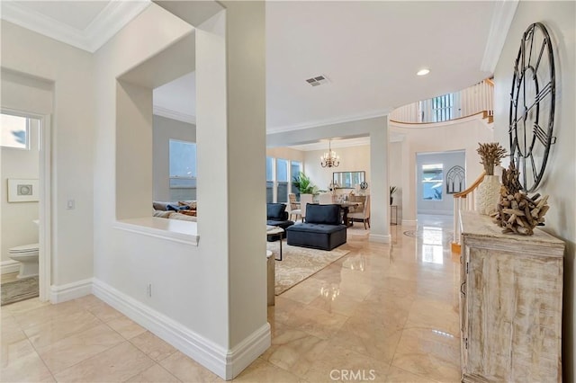 corridor featuring a chandelier, marble finish floor, crown molding, and baseboards