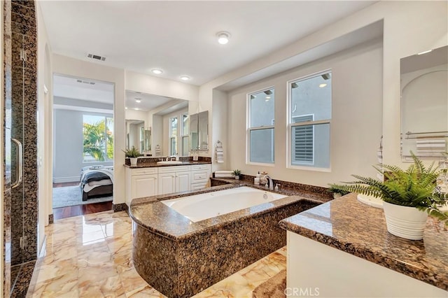 ensuite bathroom with visible vents, marble finish floor, ensuite bathroom, a bath, and vanity