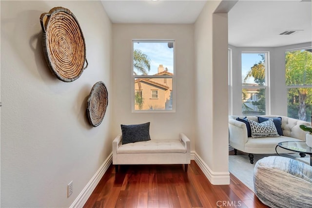 living area with visible vents, baseboards, and dark wood-style flooring