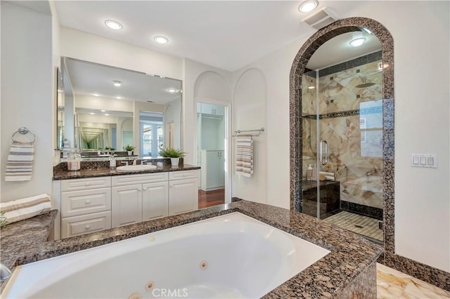 full bathroom with visible vents, vanity, a stall shower, and a whirlpool tub