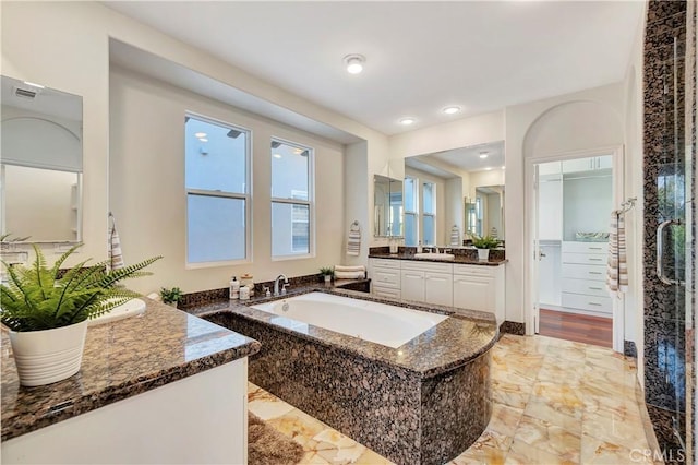 full bath featuring vanity, a bath, visible vents, and marble finish floor