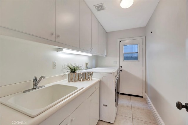 laundry room with visible vents, washing machine and dryer, light tile patterned floors, cabinet space, and a sink