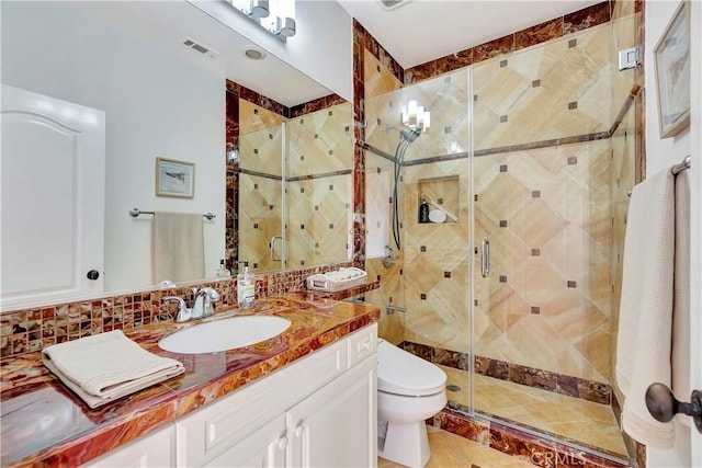 full bath featuring vanity, a shower stall, toilet, and visible vents