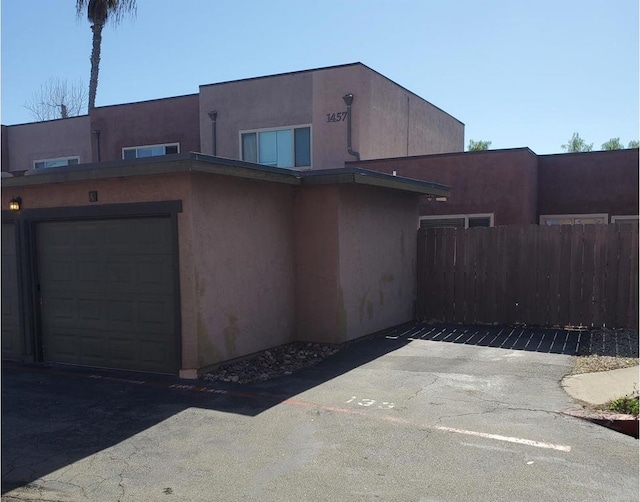 exterior space with stucco siding and fence