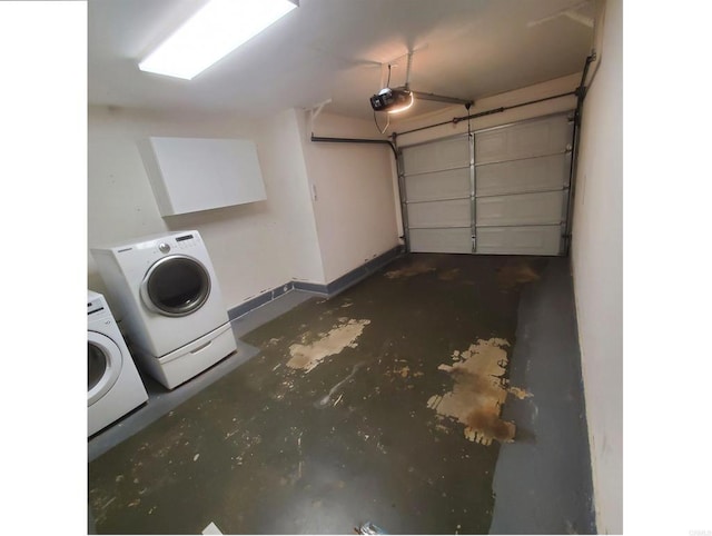 garage featuring washing machine and dryer, a garage door opener, and baseboards