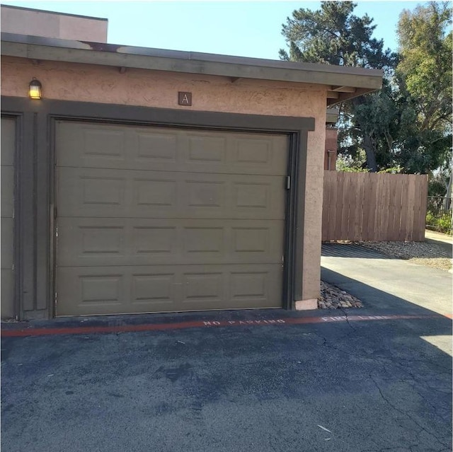 garage with fence and driveway