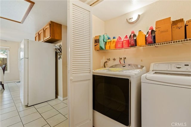 clothes washing area with light tile patterned flooring, laundry area, and washer and dryer