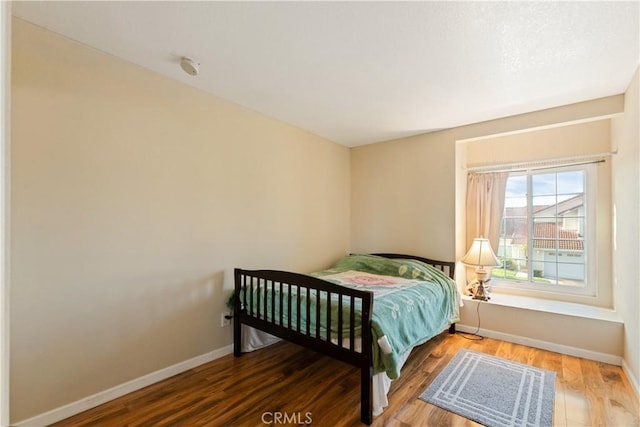 bedroom with wood finished floors and baseboards