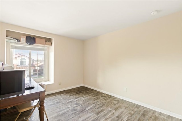 office space featuring baseboards and wood finished floors