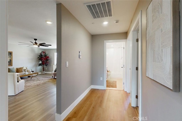 hallway featuring recessed lighting, baseboards, visible vents, and light wood finished floors