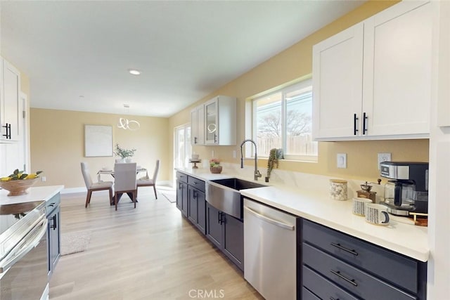 kitchen with a sink, stainless steel appliances, and white cabinetry