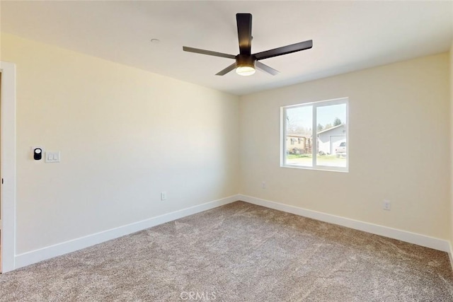 carpeted empty room featuring baseboards and ceiling fan