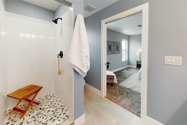 ensuite bathroom featuring baseboards, visible vents, ensuite bathroom, and walk in shower