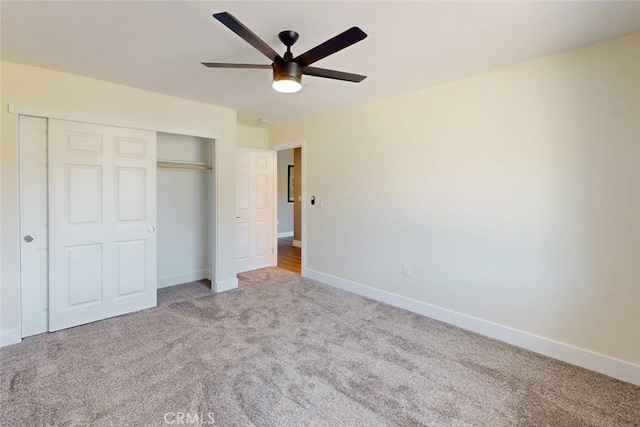 unfurnished bedroom featuring a closet, carpet floors, baseboards, and ceiling fan