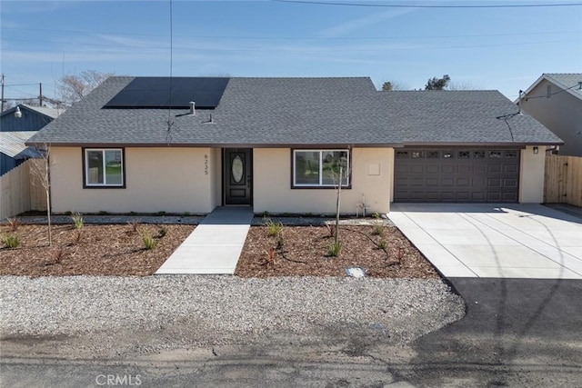 ranch-style house featuring a shingled roof, fence, a garage, and stucco siding