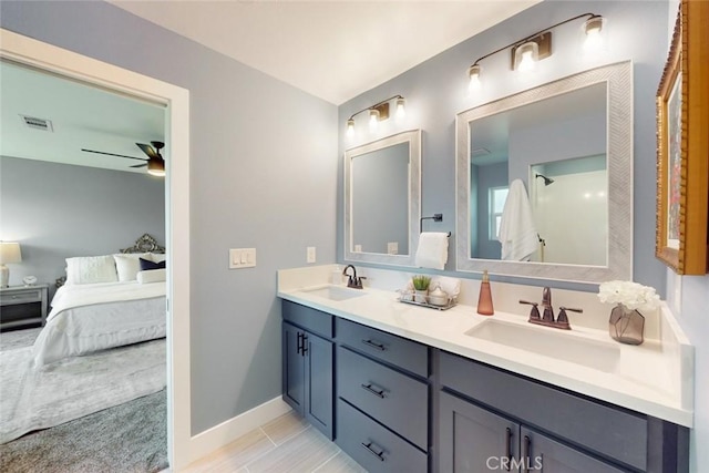 bathroom with double vanity, ensuite bath, ceiling fan, and a sink