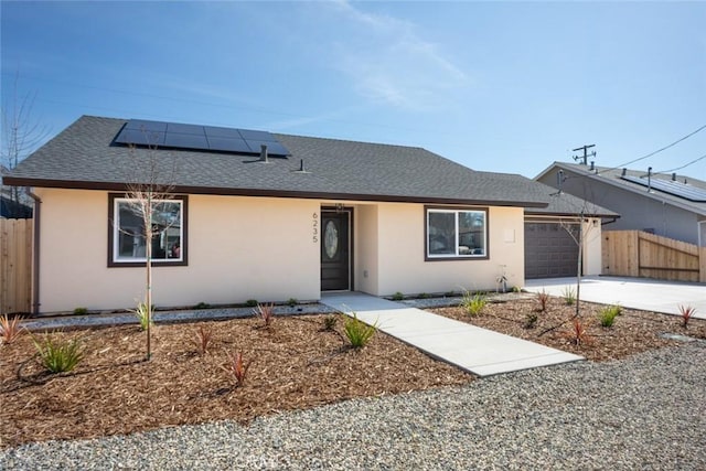 ranch-style home with a shingled roof, stucco siding, concrete driveway, and fence