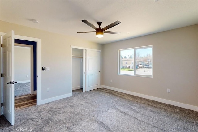 unfurnished bedroom featuring a closet, a ceiling fan, carpet, and baseboards