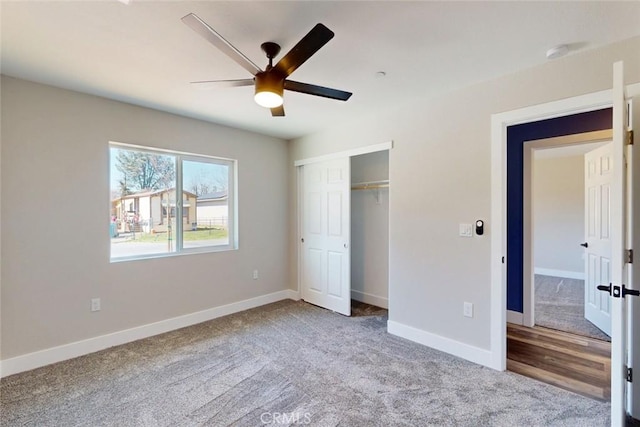 unfurnished bedroom with a closet, baseboards, carpet floors, and ceiling fan