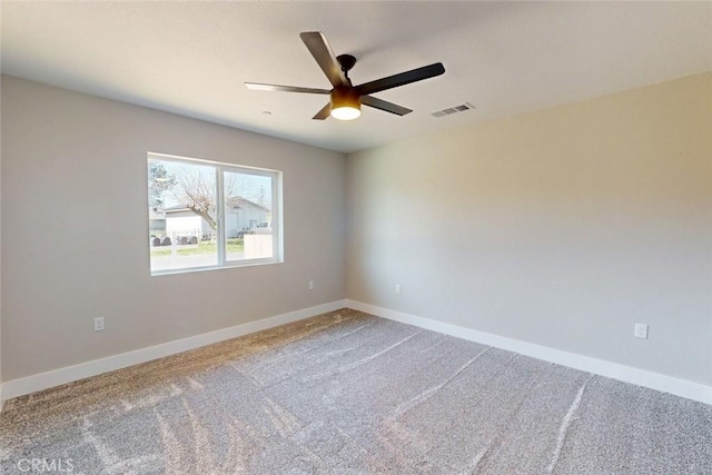 carpeted empty room with visible vents, a ceiling fan, and baseboards