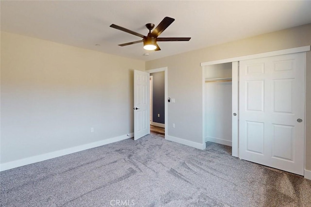 unfurnished bedroom featuring carpet, baseboards, a closet, and ceiling fan