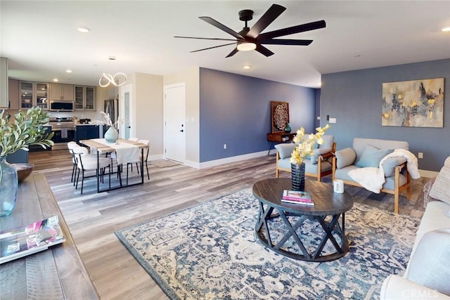 living room featuring recessed lighting, light wood-type flooring, baseboards, and ceiling fan