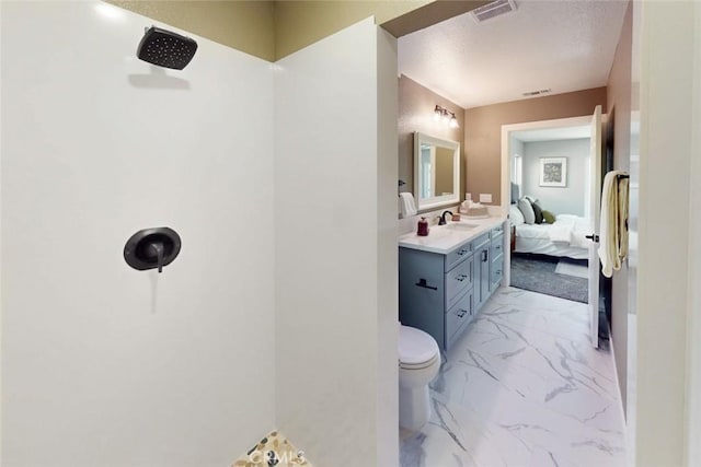 ensuite bathroom featuring vanity, toilet, visible vents, and marble finish floor