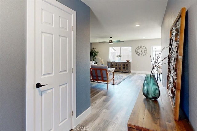 hallway featuring recessed lighting, wood finished floors, and baseboards