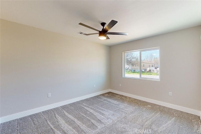 carpeted spare room featuring visible vents, ceiling fan, and baseboards