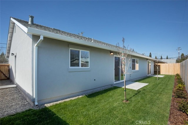 rear view of property with stucco siding, a lawn, a fenced backyard, and a shingled roof