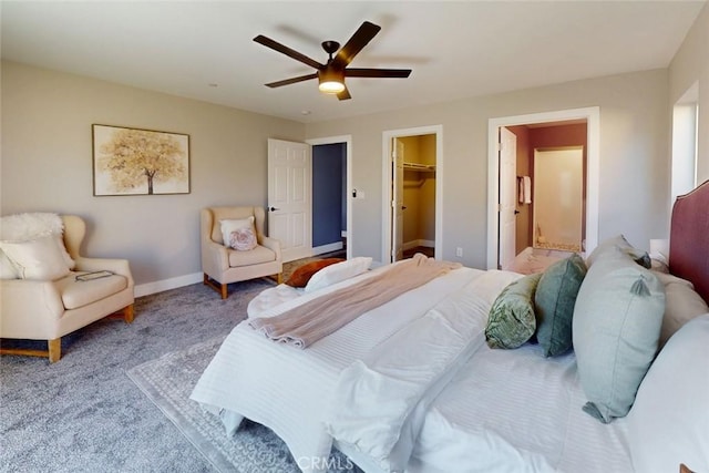 carpeted bedroom with a walk in closet, ceiling fan, baseboards, ensuite bathroom, and a closet