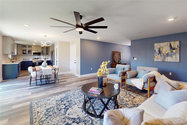 living area with recessed lighting, baseboards, ceiling fan, and light wood finished floors