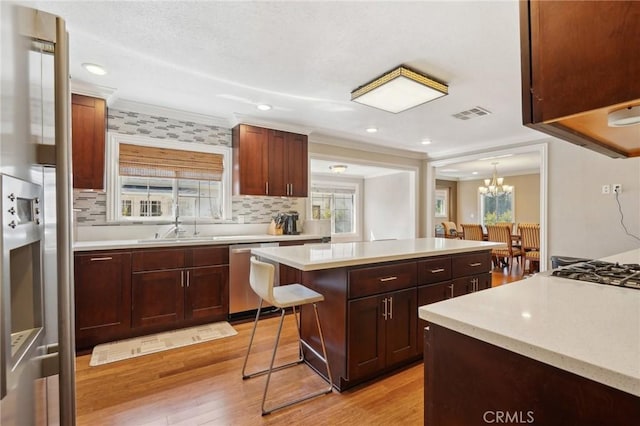 kitchen featuring dishwasher, light wood-style flooring, crown molding, and light countertops