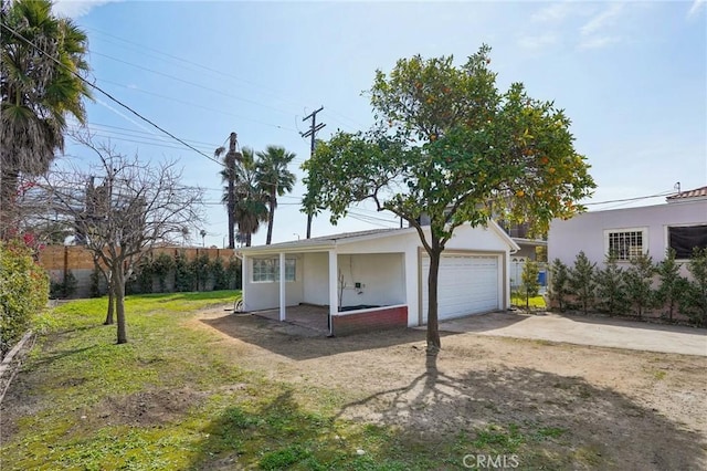 ranch-style house with concrete driveway, fence, a front yard, and stucco siding