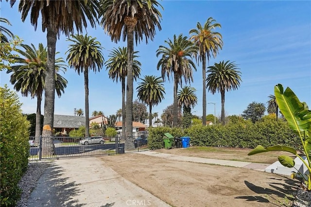 surrounding community with a gate, fence, and concrete driveway