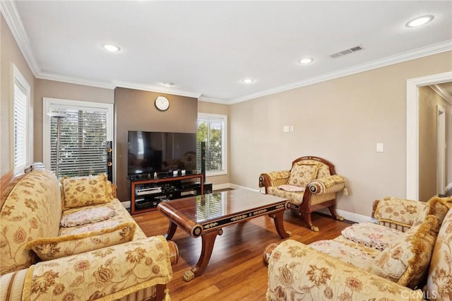 living area featuring visible vents, baseboards, ornamental molding, recessed lighting, and light wood-style floors