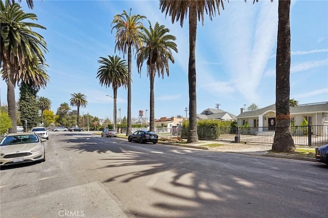 view of road with street lights, curbs, sidewalks, and a residential view