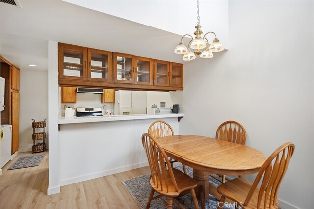 dining room with visible vents, an inviting chandelier, light wood-type flooring, and baseboards