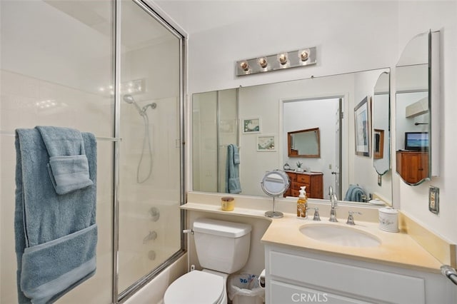 bathroom with vanity, toilet, and bath / shower combo with glass door