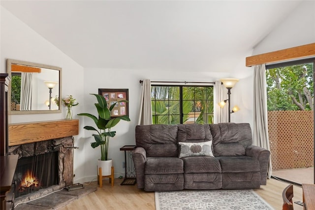 living room with wood finished floors, a fireplace, and vaulted ceiling